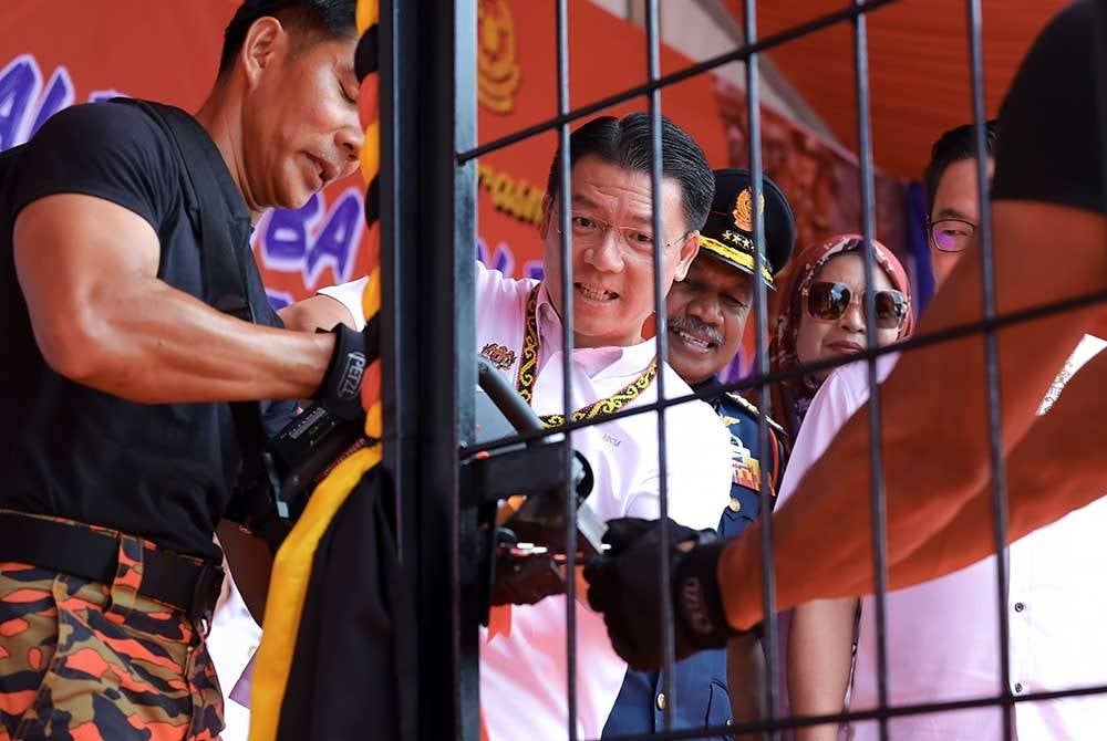 Menteri Pembangunan Kerajaan Tempatan Nga Kor Ming (tengah) memotong mangga sebagai gimik perasmian Balai Bomba dan Penyelamat Asajaya dekat sini, hari ini.