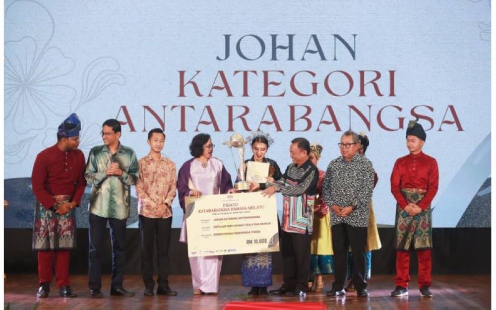Gulzoda (tengah) menerima piala pusingan daripada Timbalan Menteri Pendidikan Tinggi, Datuk Mohammad Yusof Apdal (depan, dua dari kanan) selepas diumumkan sebagai johan Kategori Antarabangsa PABM 2023.