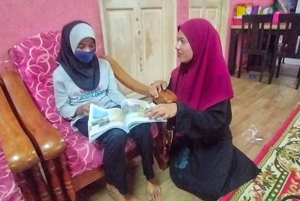Fasehha (dua dari kiri) menemani Nur Najihah mengulang kaji pelajaran.
