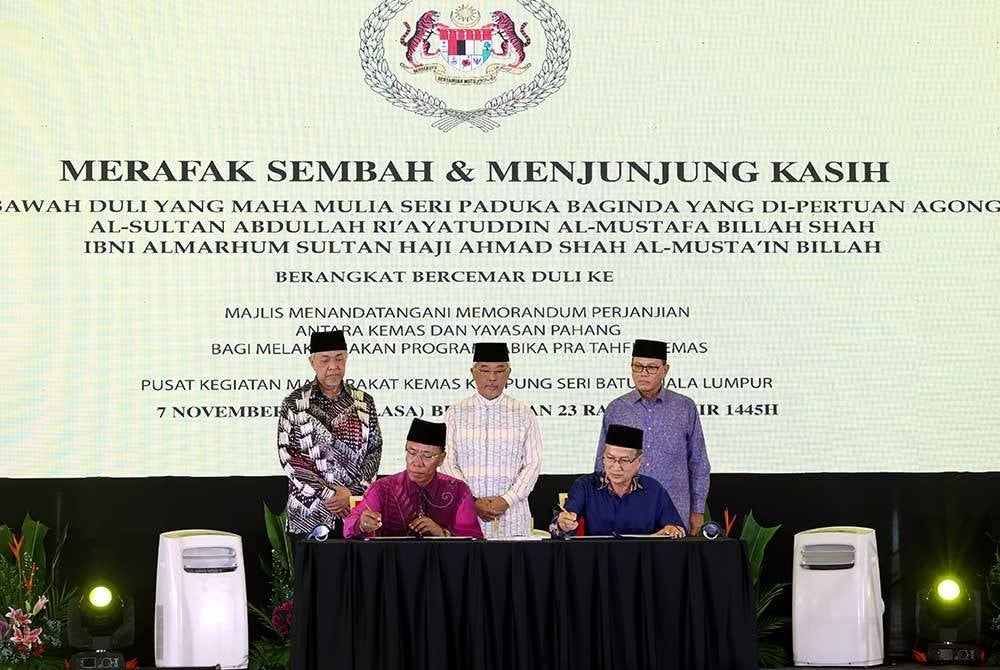 Al-Sultan Abdullah (berdiri, tengah) berkenan menyaksikan pemeteraian MoA antara Kemas dan Yayasan Pahang. - Foto Bernama