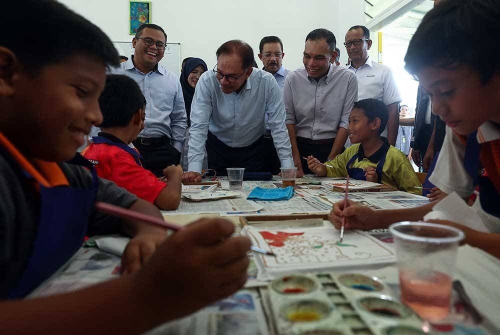 Anwar beramah mesra bersama murid sekolah pada majlis penyerahan dan perasmian Projek Rintis Bangunan Daif di Sekolah Kebangsaan Bandar Baru Bangi hari ini. - Foto Bernama