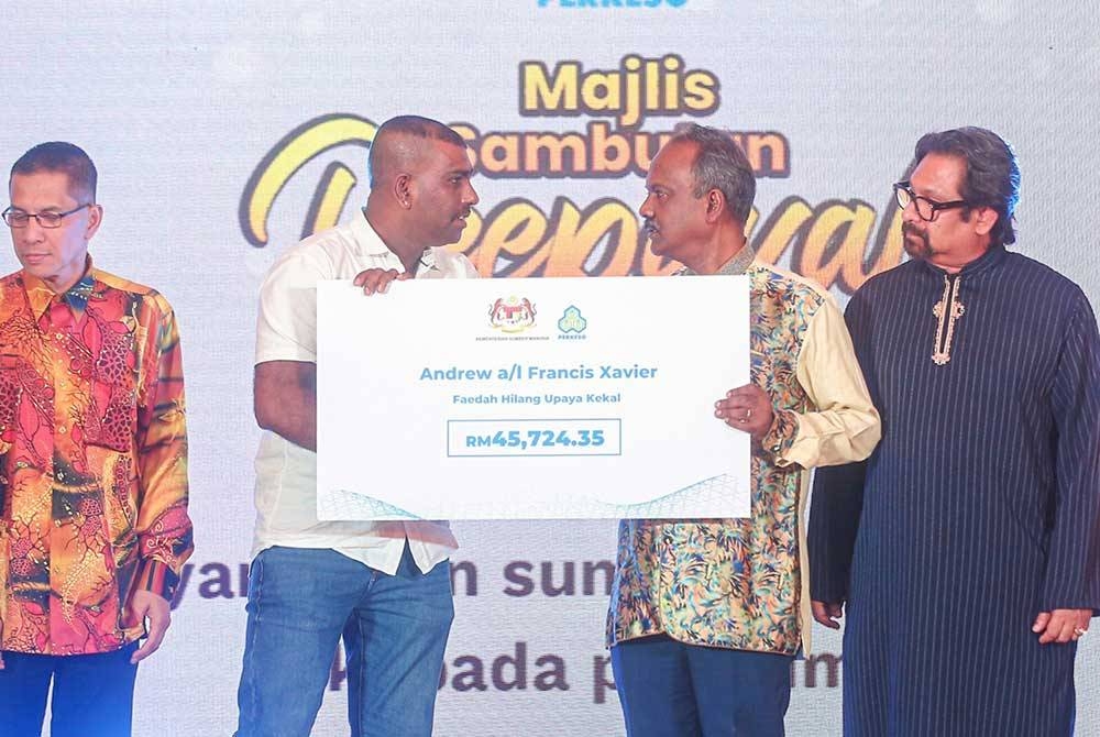Sivakumar (dua dari kanan) menyampaikan bantuan faedah Perkeso, hilang upaya kekal kepada FX Andrew berjumlah RM45,724.35.