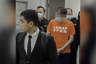 Seorang penguat kuasa (kanan) yang memakai baju lokap dibawa ke Mahkamah Majistret Shah Alam untuk mendapatkan perintah reman bermula Selasa.