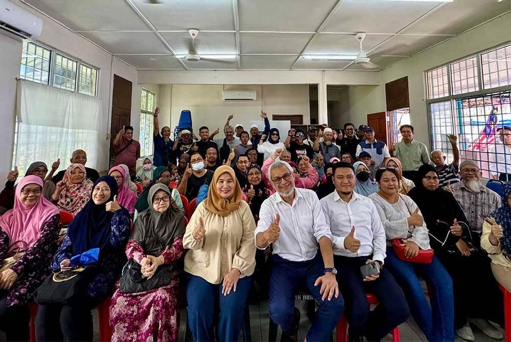 Lele Suzana (empat kiri) dan Khalid (lima dari kanan) bersama penduduk rumah teres Kampung Sungai Baru pada sidang akhbar pada Rabu.