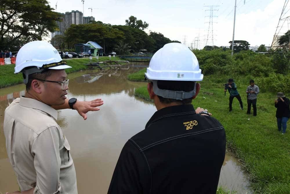Nik Nazmi (kiri) meninjau tapak pelaksanaan projek Rancangan Tebatan Banjir (RTB) Taman Siakap hari ini. - Foto Bernama