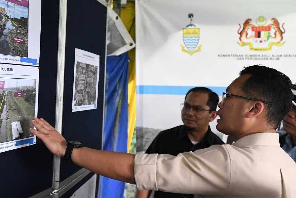 Nik Nazmi (kanan) meninjau tapak pelaksanaan projek Rancangan Tebatan Banjir (RTB) Taman Siakap hari ini. - Foto Bernama