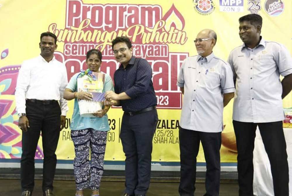 Shahrin (tiga dari kanan) menyampaikan sumbangan kepada salah seorang penerima di Dewan Azalea, Seksyen 25 Shah Alam.