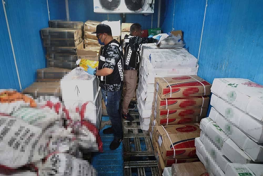 Anggota Penguatkuasa Kementerian Perdagangan Dalam Negeri dan Kos Sara Hidup (KPDN) memeriksa sebuah kontena yang memuatkan daging babi, ayam, itik dan ikan secara bercampur sewaktu mengadakan operasi bersepadu bersama Jabatan Perkhidmatan Veterinar dan Kementerian Kesihatan di sebuah premis, pada Rabu. - Foto Bernama