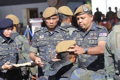 Ayob Khan memakaikan beret simbolik pentauliahan peserta kursus asas 69 Komando di Kem Sultan Nazrin Shah, Ulu Kinta pada Rabu.