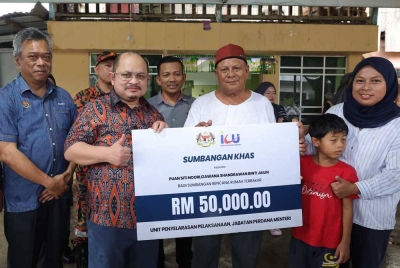 Shamsul Iskandar menyerahkan replika cek bernilai RM50,000 sumbangan daripada Jabatan Perdana Menteri (JPM) kepada mangsa kebakaran Jalin Bin Toh di Kampung Pirasan Kota Belud hari ini. - Foto Bernama