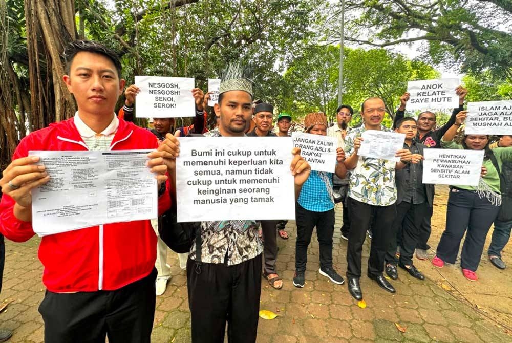 Mustafa (dua dari kiri) dan Hafizudin (kiri) yang mempamerkan risalah bantahan cadangan ubah suai KSAS.