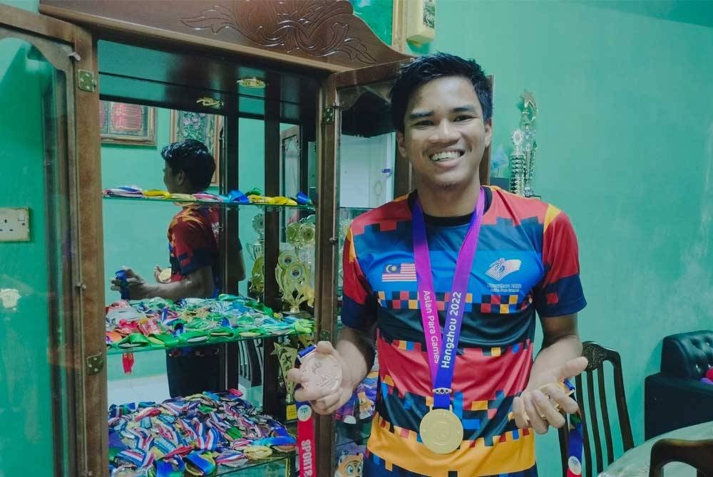 Almari khas menyimpan pingat dan piala dimenangi Ammar Aiman di ruang tamu rumah di Pekan Nanas, Pontian.