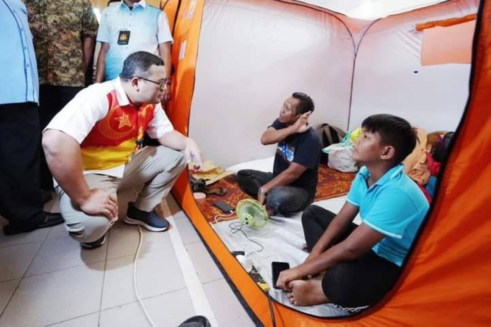 Amirudin (kiri) berbual bersama mangsa banjir.