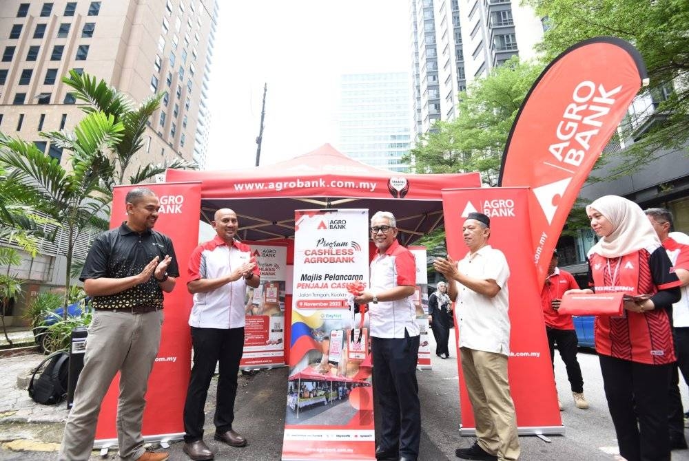 Tengku Ahmad (tengah) memotong riben sempena Majlis Pelancaran Penjaja Cashless di Jalan Tengah, Kuala Lumpur pada Khamis.