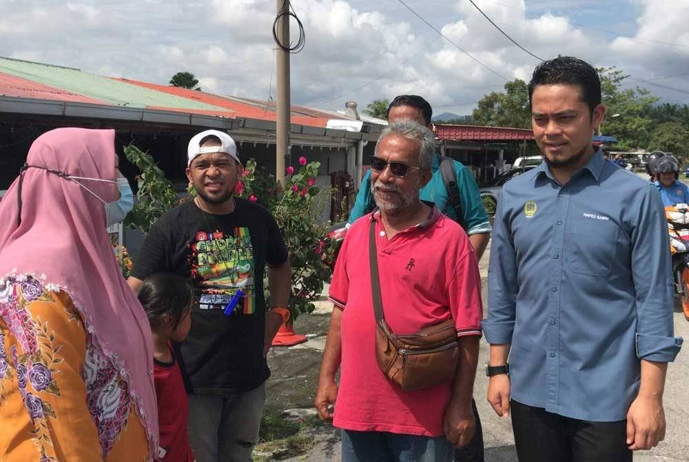 Mohd Hafez (kanan) bersama Ketua Penolong Pegawai Daerah Kinta (Pembangunan), Dr Kamarul Liza Hashim turun padang meninjau kerosakan yang dialami penduduk.