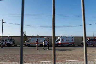 Deretan ambulans yang membawa rakyat Palestin tercedera menunggu di lintasan Rafah untuk ke Mesir. - Foto: Reuters