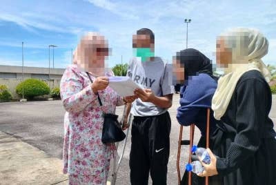 Jay (dua dari kiri) bersama ahli keluarga yang menantinya keluar dari Penjara Sungai Udang, pada Khamis.