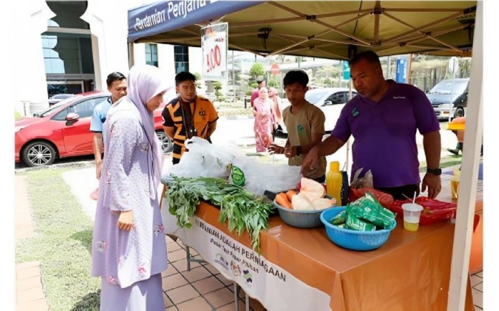 Seorang pengguna melihat sayur-sayuran yang segar dijual di JAM. 
