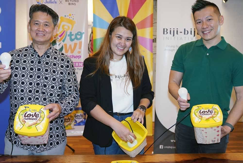 Horng Sai (kanan), Juliana (tengah) dan Martin Ang menunjukkan dekorasi lampu menggunakan tab plastik 'Love Letters'.