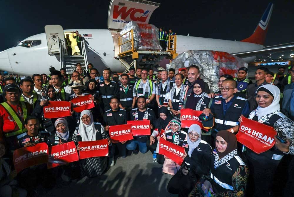Fadillah bersama anggota NGO semasa majlis penghantaran kedua barangan keperluan utama bantuan kemanusiaan untuk rakyat Palestin di Gaza melalui penerbangan kargo sewaan khas di Terminal Kargo KLIA malam Jumaat. Foto: Bernama