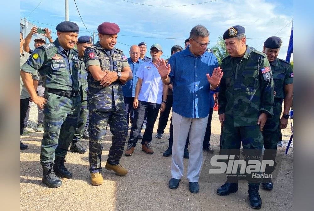 Saifuddin Nasution (dua dari kiri) membincangkan sesuatu dengan salah seorang pegawai PGA semasa melawat Pos Nibong di Tumpat.