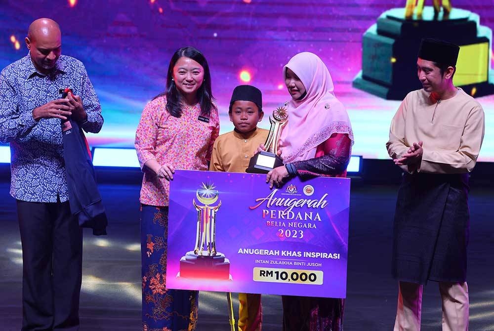 Hannah (dua dari kiri) menyampaikan Anugerah Khas Inspirasi kepada Intan Zulaikha (dua dari kanan) bersama muridnya, Muhammad Aqil Naufal (tengah) pada majlis penyampaian Anugerah Perdana Belia Negara 2023 di Auditorium Cempaka Sari, Perbadanan Putrajaya hari ini. - Foto Bernama