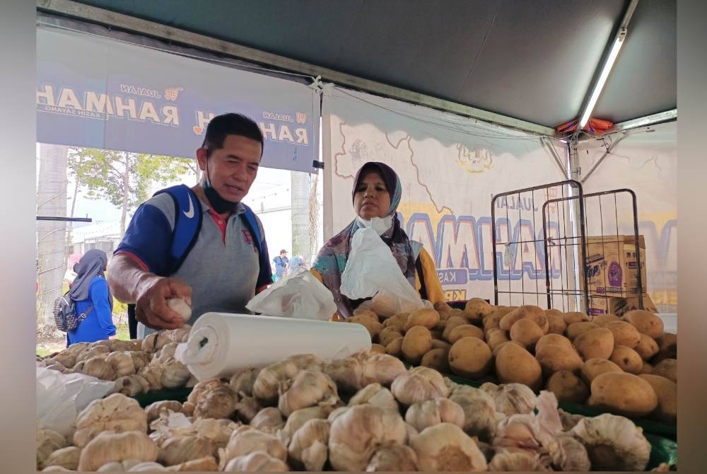 Saniah bersama suami memilih bawang dan kentang sempena Jualan Agro Madani di HPPNK 2023.