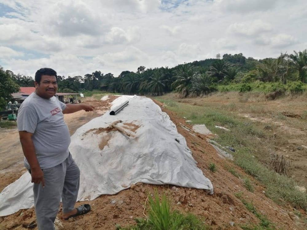Rohaizal menunjukkan ban yang telah ditinggikan di sungai berhampiran rumah penduduk.