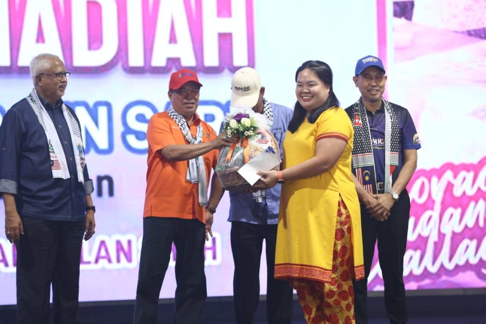 Mohamad menyampaikan hadiah kepada pemenang Badang Challenge, Tee Ghia Hoong, 35.