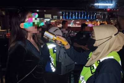 Anggota penguatkuasa JAINJ melakukan pemeriksaan ke atas seorang wanita dalam Op Hibur Bersepadu di sebuah premis hiburan di Johor Bahru pada awal pagi Ahad.