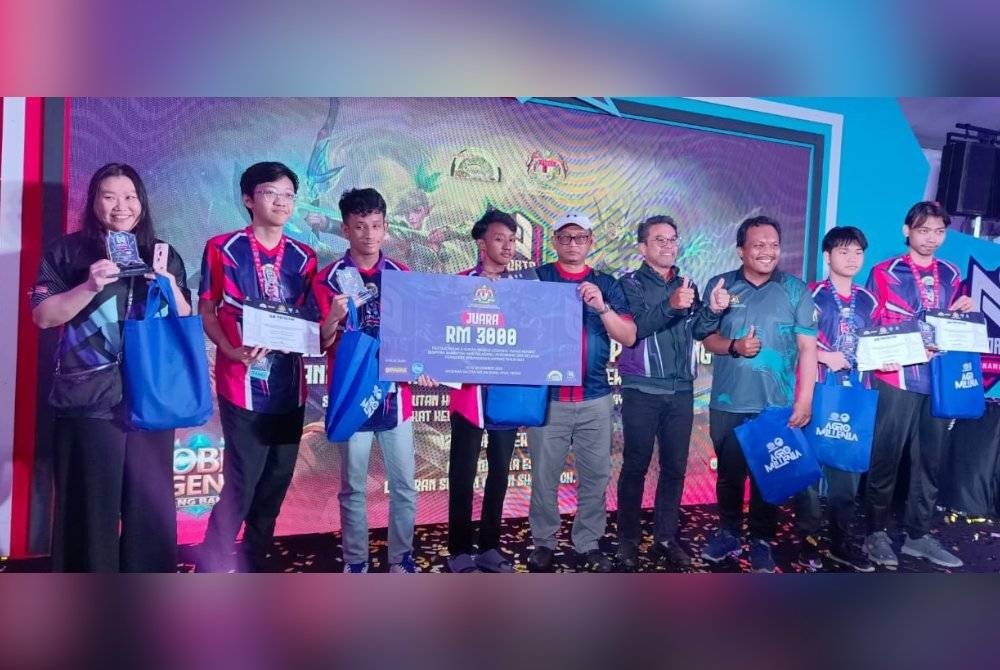Nik Mohd Shaharil menyampaikan hadiah kemenangan kepada kumpulan Miracle Gaming.