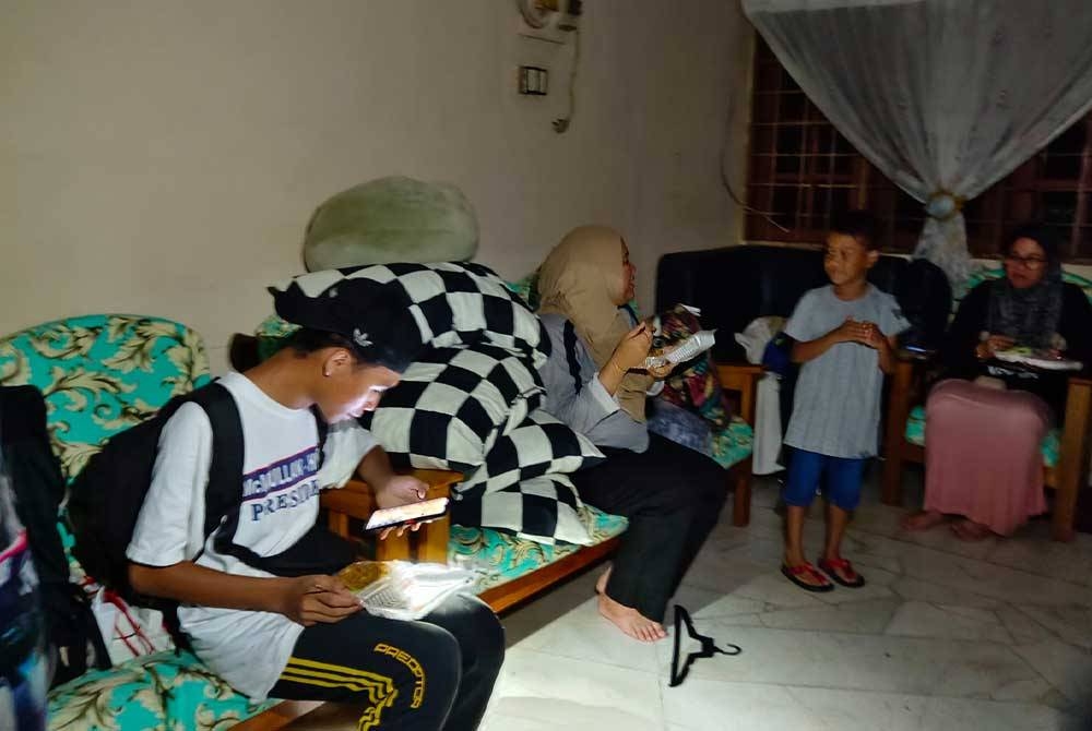 Mangsa menikmati makanan dalam gelap selepas rumah mereka terkena ribut.