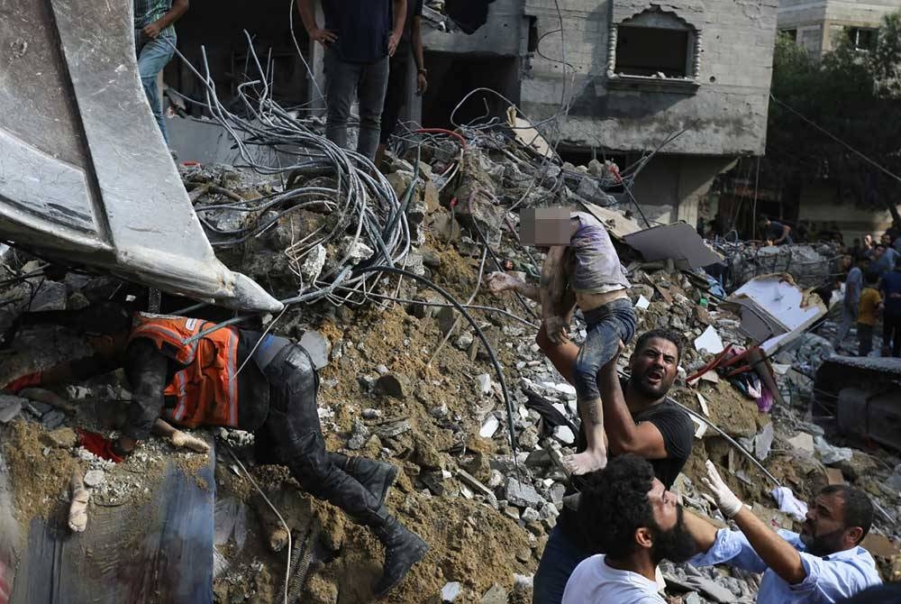 Penduduk mengeluarkan mayat kanak-kanak yang maut dalam serangan udara Israel yang menyasarkan kawasan kediaman di Kota Gaza. - Agensi