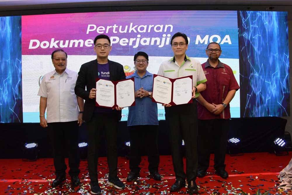 Kien Poon (dua dari kiri), Menteri Pembangunan Usahawan dan Koperasi, Datuk Ewon Benedick (tengah) serta Rizal (dua dari kanan) semasa majlis pertukaran Memorandum Perjanjian (MoA) di Sesi Meet & Greet Alumni TUBE di Kota Kinabalu, Sabah.