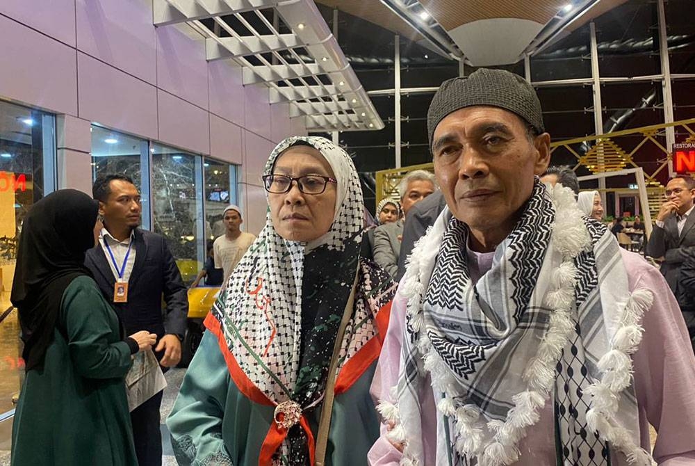 Haron Hamim (kanan) dan Mastura Yusof (kiri) ketika menunggu ketibaan anaknya, Nurul Ain dan Mohamed Adan di Terminal 1, KLIA pada Selasa.