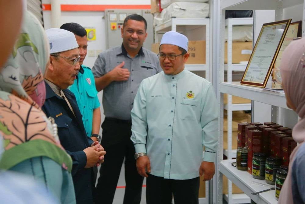 Tuan Mohd Saripudin (kanan) semasa membuat lawatan di kilang cuka rambutan dan dokong di Pengkalan Chepa.