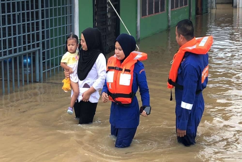 Anggota APM Alor Setar membantu memindahkan penduduk ke PPS SK Titi Gajah, Alor Setar pada petang Selasa.