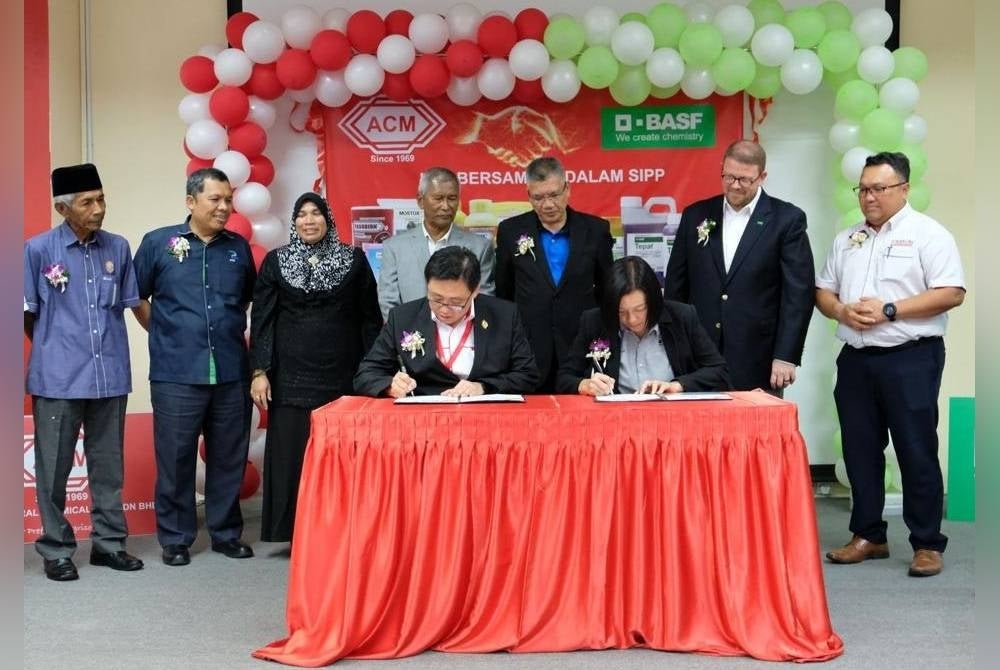 Kevin (duduk, kiri) dan Janice (duduk, kanan) menandatangani perjanjian tersebut sambil disaksikan Ismail (berdiri, empat dari kiri).