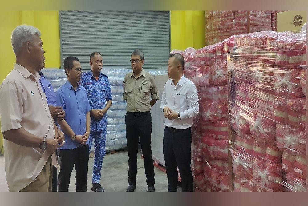 Khairul Shahril (dua dari kanan) dan Timbalan Menteri Pertanian dan Keterjaminan Makanan, Datuk Chan Foong Hin (kanan) mendengar penerangan daripada wakil FAMA semasa melawat gudang penyimpanan sebelum Majlis Pelepasan Pengedaran Kit Makanan MTL di Pusat Memproses Makanan FAMA Kuala Selangor pada Rabu.