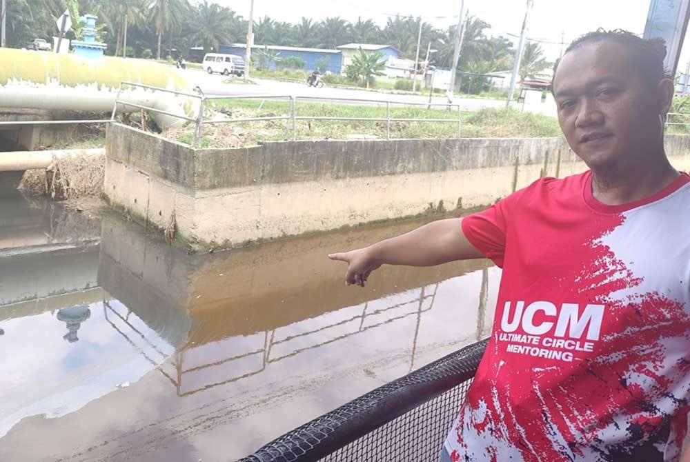 Nasruddin menunjukkan aliran air bertukar warna hitam dan berbau busuk di Parit Jalan Haji Abd Wahid di sini pada Rabu.