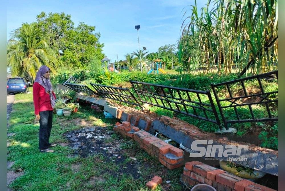 Shahila menunjukan runtuhan tembok penghadang di hadapan rumahnya di, Rumah Rakyat Gunung Lambak.