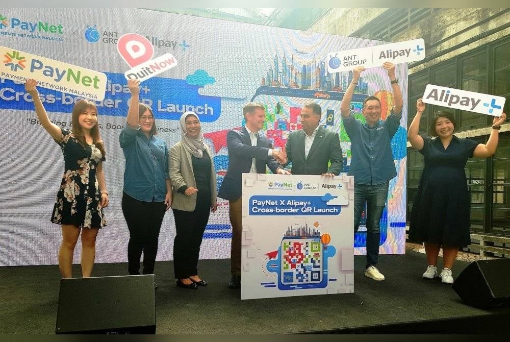 Farhan (tiga dari kiri) bersalaman dengan Feagin pada majlis pelancaran kerjasama pembayaran digital rentas sempadan mereka yang diadakan di Kuala Lumpur, baru-baru ini.