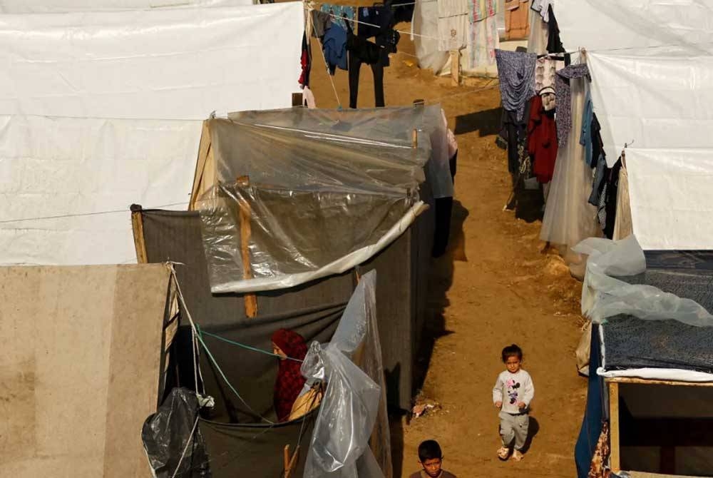 Laluan lecak dan berlumpur sekitar khemah sementara tersebut. - Foto: AFP