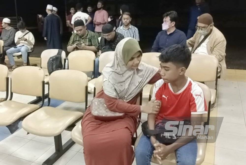 Nordiana menenangkan anaknya, Sallman Elkhoyri semasa menanti urusan bedah siasat di rumah mayat HSI Johor Bahru pada malam Rabu.