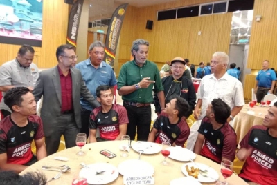 Khairy Jamaluddin (berdiri, empat kiri) berkesempatan beramah mesra dengan pelumba terlibat.