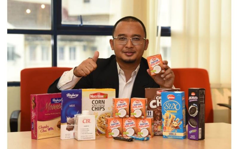 Muhammad Hisyam menunjukkan produk-produk selain santan kelapa yang dikeluarkan oleh syarikatnya. 