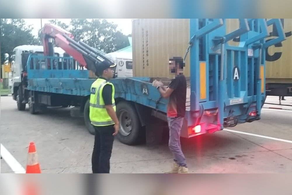 Anggota JPJ membuat pemeriksaan ke atas seorang pemandu treler pada Op Patuh di Kawasan Rehat dan Rawat Gurun pada petang Rabu.
