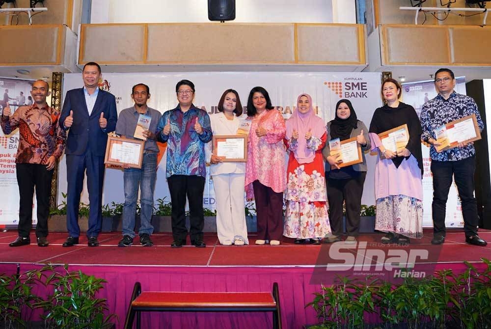 Ewon (empat dari kiri) dan tetamu kehormat bersama peserta terbaik program pada Majlis Penyerahan Dana Fasilitasi SME Bank iTekad Penjana Komuniti 2023 di Kuala Lumpur pada Khamis. - Foto SINAR HARIAN/MOHD HALIM ABDUL WAHID