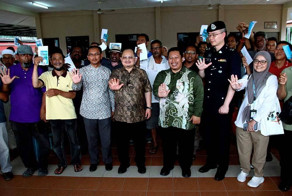 Shamsul Iskandar (tengah) bergambar bersama mangsa ribut. - Foto Bernama