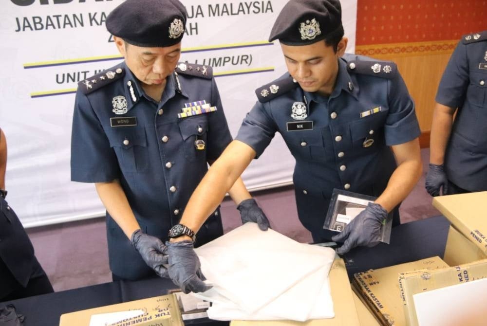 
Pun Sian (kiri) menunjukkan kotak kecil berisi dadah yang dirampas kastam.